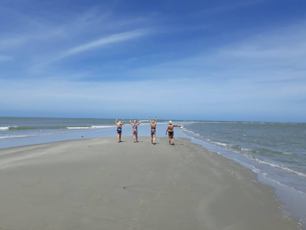 Turistas andando entre as ondas